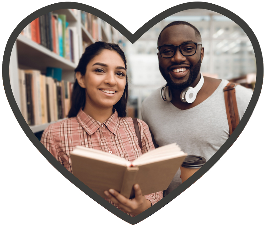 Two people standing and smiling in library